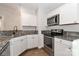 Well-lit kitchen featuring granite countertops, white cabinetry, and stainless steel appliances at 6409 Pineburr Ct, Charlotte, NC 28211
