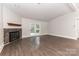 Bright living room with a ceiling fan and a stone fireplace with wooden mantel and access to outdoors at 6409 Pineburr Ct, Charlotte, NC 28211