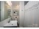 Bathroom featuring a sink, toilet, shower with curtain, and shelving at 712 2Nd Nw Ave, Conover, NC 28613