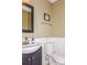 Half bathroom with a dark vanity, framed mirror and white wainscoting at 7128 Rock Bass Ct, Concord, NC 28025