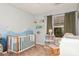 Charming bedroom featuring a crib, a cozy chair, and nature-themed decor at 7128 Rock Bass Ct, Concord, NC 28025