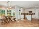 Sunlit dining area with large windows, a rustic table, and tile flooring at 7128 Rock Bass Ct, Concord, NC 28025