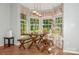 Bright dining area with large windows, rustic dining set, and tile flooring at 7128 Rock Bass Ct, Concord, NC 28025