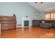 Living room showcasing a piano, fireplace, comfortable sofa, hardwood flooring and high ceilings at 7128 Rock Bass Ct, Concord, NC 28025
