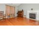 Open living room with fireplace, piano, hardwood flooring, rocking chair and neutral walls at 7128 Rock Bass Ct, Concord, NC 28025