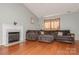 Inviting living room with a cozy fireplace, a large sectional sofa, and hardwood floors at 7128 Rock Bass Ct, Concord, NC 28025