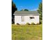 A small white home has a green roof, and manicured landscaping at 716 E Union St, Marshville, NC 28103