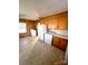 Kitchen with wood cabinets, white appliances, and laminate flooring at 716 E Union St, Marshville, NC 28103