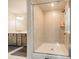 A well-lit bathroom featuring a glass-enclosed shower, gray vanity, and neutral tile, creating a spa-like experience at 804 Lyndon Station Dr, Pineville, NC 28134