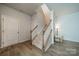 Spacious entryway features staircase with carpeted steps and wood railing at 804 Lyndon Station Dr, Pineville, NC 28134