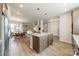 Open-concept living room with stainless steel appliances, a center island with seating, and light wood floors at 804 Lyndon Station Dr, Pineville, NC 28134