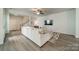 Open-concept living room features a large sectional sofa, ceiling fan, and staircase at 804 Lyndon Station Dr, Pineville, NC 28134