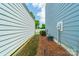 Narrow side yard between two homes with grass, pine straw, and yard lights at 804 Lyndon Station Dr, Pineville, NC 28134
