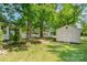 Backyard featuring a storage shed, mature trees providing shade, and a well-manicured lawn at 814 Independence Dr, Wingate, NC 28174