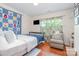 Comfortable bedroom features a large window and hardwood floors with a TV on the wall at 814 Independence Dr, Wingate, NC 28174