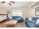 Cozy living room with blue couches, wood floors, and a ceiling fan at 814 Independence Dr, Wingate, NC 28174