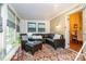 This sun room features great sunlight, a comfortable couch, and indoor/outdoor carpet at 814 Independence Dr, Wingate, NC 28174