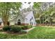 Charming home exterior with lush green lawn, mature trees, and well-maintained landscaping at 8233 Christmas Ct, Charlotte, NC 28216