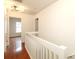 Bright upstairs hallway with hardwood flooring and white railing at 8233 Christmas Ct, Charlotte, NC 28216