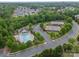 Aerial view of community amenities, including a pool, clubhouse, and tennis courts, nestled in a wooded area at 8707 Darcy Hopkins Dr, Charlotte, NC 28277