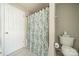 Bathroom featuring a toilet, shower with patterned curtain, door, and a neutral color scheme at 8707 Darcy Hopkins Dr, Charlotte, NC 28277