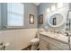 Charming half bathroom with granite counters, decorative mirror, and panel molding at 8707 Darcy Hopkins Dr, Charlotte, NC 28277
