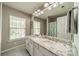Bright bathroom with double sinks, granite countertops, and decorative vanity lighting over a large mirror at 8707 Darcy Hopkins Dr, Charlotte, NC 28277