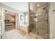 Bright bathroom featuring a soaking tub and glass enclosed shower with a view to the main bedroom at 8707 Darcy Hopkins Dr, Charlotte, NC 28277