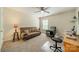 Neutral-toned bedroom with ceiling fan features a futon, chair, desk, and large window at 8707 Darcy Hopkins Dr, Charlotte, NC 28277