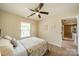 Relaxing bedroom features a ceiling fan and large window. Doorway to another room is present at 8707 Darcy Hopkins Dr, Charlotte, NC 28277