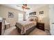 Relaxing bedroom with ceiling fan has a large window, wrought iron bed frame, and side tables at 8707 Darcy Hopkins Dr, Charlotte, NC 28277
