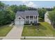 Traditional two-story home featuring a two-car garage, well-maintained lawn, and mature trees at 8707 Darcy Hopkins Dr, Charlotte, NC 28277