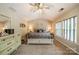 Serene main bedroom with neutral tones, carpeted floors, large windows, and a ceiling fan at 8707 Darcy Hopkins Dr, Charlotte, NC 28277