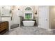 Bright bathroom with a soaking tub, walk-in shower, and herringbone tile floors at 9013 Yellow Pine Ct, Waxhaw, NC 28173