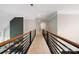Upstairs hallway featuring metal railing, neutral carpet, and shiplap accent wall at 9013 Yellow Pine Ct, Waxhaw, NC 28173
