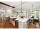 Well-appointed kitchen featuring an island with seating, stainless steel appliances, and hardwood floors at 9013 Yellow Pine Ct, Waxhaw, NC 28173
