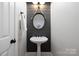 Charming powder room with shiplap accent wall, pendant mirror, pedestal sink, and white door at 9013 Yellow Pine Ct, Waxhaw, NC 28173