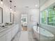 Bright bathroom with soaker tub, marble floors, and modern fixtures offers luxury and relaxation at 910 Everett Pl, Charlotte, NC 28205