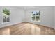 Bright bedroom with hardwood flooring and two windows offering natural light and views at 910 Everett Pl, Charlotte, NC 28205