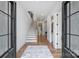 Bright foyer showcasing hardwood floors, a staircase with wood treads and white risers, and modern lighting at 910 Everett Pl, Charlotte, NC 28205