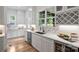 Bright kitchen features white cabinets, stainless steel appliances, and a quartz countertop with a view out of the window at 910 Everett Pl, Charlotte, NC 28205