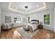 Main bedroom with hardwood floors, modern lighting, and natural light from surrounding windows at 910 Everett Pl, Charlotte, NC 28205