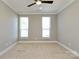 Neutral bedroom with carpet, two windows, ceiling fan and white trim at 926 Steel House Blvd, Charlotte, NC 28205