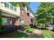 Brick townhome exterior with manicured landscaping and sidewalk lined with trees at 926 Steel House Blvd, Charlotte, NC 28205