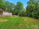 Lush backyard with green grass and trees surrounding a house at 981 Meadowlark Dr, Rock Hill, SC 29732