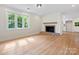 Spacious living room featuring hardwood floors, a brick fireplace, and ample natural light from large windows at 981 Meadowlark Dr, Rock Hill, SC 29732