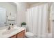 Clean bathroom featuring a shower with curtain, modern sink, and vanity cabinet at 1027 Feather Oak Ln, Matthews, NC 28104