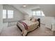 Cozy bedroom featuring plush carpet, comfortable bed, three windows, and natural light at 1027 Feather Oak Ln, Matthews, NC 28104