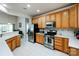 Bright kitchen featuring stainless steel appliances, light oak cabinets, and white countertops and floors at 1027 Feather Oak Ln, Matthews, NC 28104