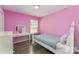 This bedroom has a bed, vanity, hardwood floors, and is painted pink at 11224 Amber Glen Dr, Charlotte, NC 28269